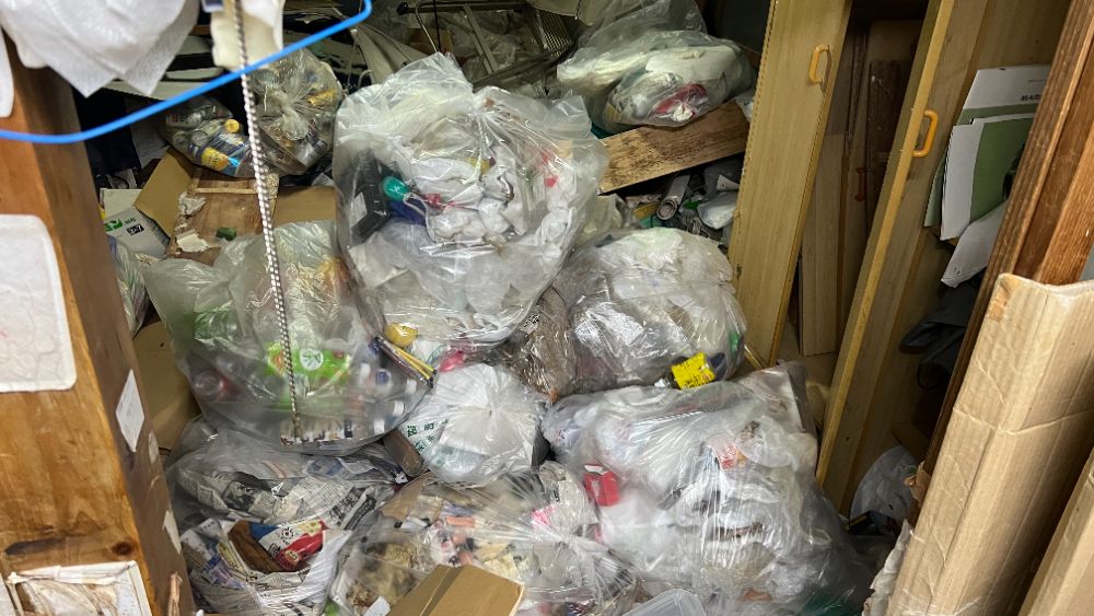 作業前：袋に入った不用品が天井近くまで積み上がった室内