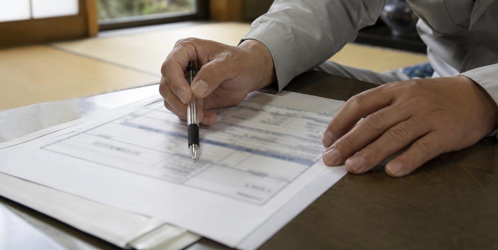 見積書をペンで指し示しながら説明する手元